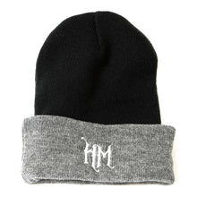 Gray and black beanie with cuff with Haunted Museum "HM" logo embroidered on the cuff